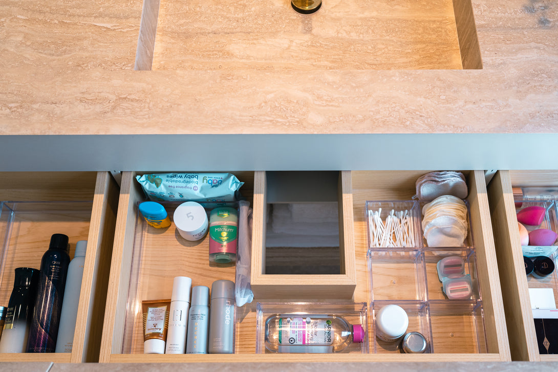 Close-up of an open drawer in the custom vanity, revealing the handcrafted oak compartments and integrated mirror, neatly organising bathroom products.